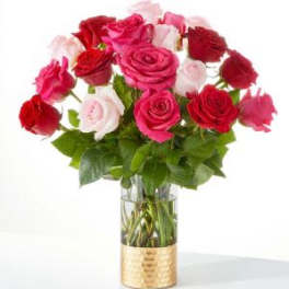 Bouquet of red, pink, and white roses in a clear glass vase