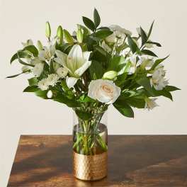 White lilies and roses in a clear glass vase
