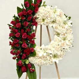 Two floral wreaths on easels, one red and one white.