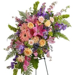Standing floral spray with pink lilies, roses, and purple flowers