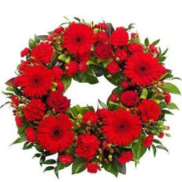 Red gerbera and rose wreath with green foliage