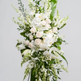 Tall white floral standing arrangement with roses and orchids