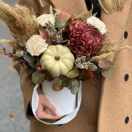 Autumn bouquet with chrysanthemums and a small pumpkin in a white bucket
