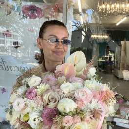 Woman holding a large pastel bouquet in a white box