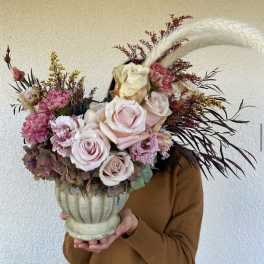 Large pastel bouquet in a cream urn vase with roses and carnations