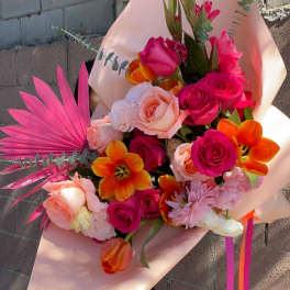 Bouquet of pink and orange roses with tulips and pink palm fronds