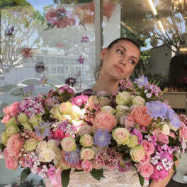Large basket arrangement of pink and cream roses with lavender flowers