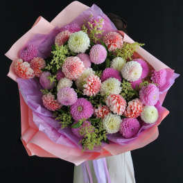 Large bouquet of pink, white, and peach dahlias wrapped in pastel paper