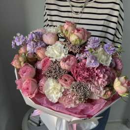 Large bouquet of pink and lavender flowers wrapped in white paper