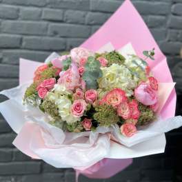Pink and white bouquet of roses and hydrangeas wrapped in pastel paper