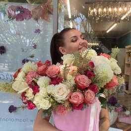 Woman holding a large bouquet of pink, white, and coral roses