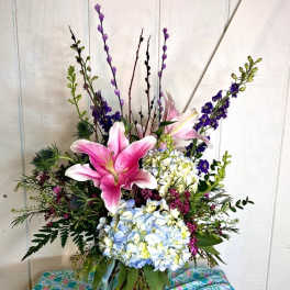 Pink lilies and blue hydrangeas in a mixed vase arrangement