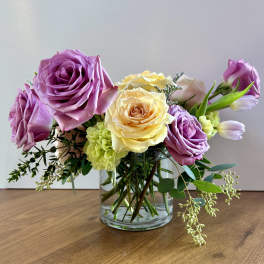Bouquet of pink and yellow roses in a clear glass vase