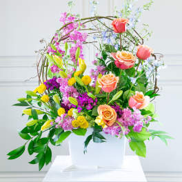 Colorful floral arrangement in a white container with roses and lilies