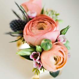 Small bouquet of peach ranunculus and tiny pink flowers