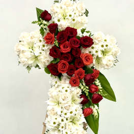 Standing floral cross with red and white roses and lilies on an easel