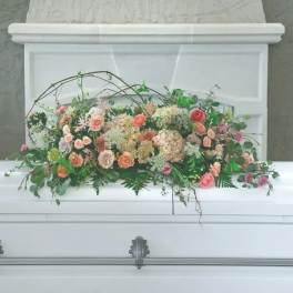 Pastel floral casket spray with roses and greenery