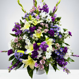 Large bouquet of white lilies, purple flowers, and white daisies in a vase
