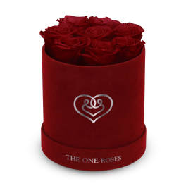 Red roses arranged in a velvet round box with a heart emblem