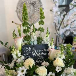 Sympathy floral arrangement with white flowers and a memorial sign