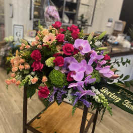 Large mixed bouquet with pink roses and lavender orchids on a stand