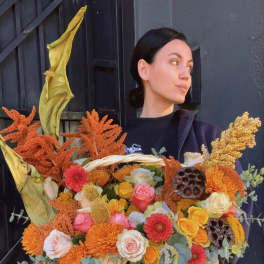 Large basket of orange, yellow, pink, and white flowers