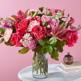 Pink rose bouquet in a clear glass vase on a table
