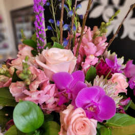 Pink roses and purple orchids in a glass vase