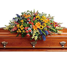 Colorful floral spray arranged on a wooden casket
