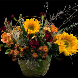 Basket arrangement with sunflowers, burgundy blooms, and orange flowers