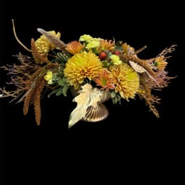 Autumn floral arrangement with yellow and orange blooms in a gold vase