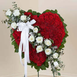 Heart-shaped red floral spray with white roses and a white ribbon