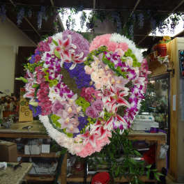 Large heart-shaped floral wreath with pink, white, purple, and red blooms