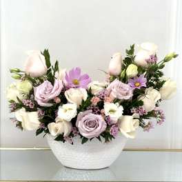 Pastel roses and cosmos arranged in a white bowl vase