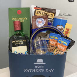 Father's Day gift basket with whiskey, snacks, and a blue box