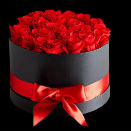 Red roses arranged in a black round box with a red ribbon