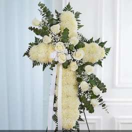 White floral cross arrangement with roses and ribbon