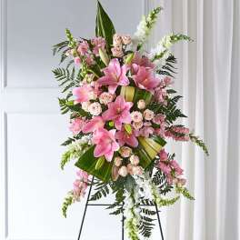 Pink lilies and roses arranged on a standing easel
