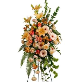 Tall standing floral spray with peach and pink flowers on a metal easel