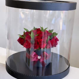 Red roses in a black hatbox with a clear dome cover