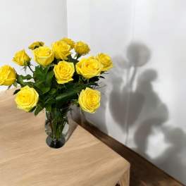 Yellow roses arranged in a clear glass vase