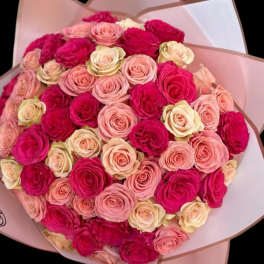 Bouquet of pink and cream roses wrapped in pale paper