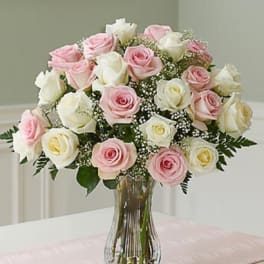 Bouquet of pink and white roses in a clear glass vase