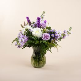 Lavender and white flower arrangement in a textured glass vase