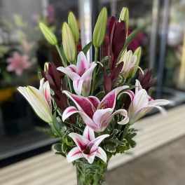 Bouquet of pink and white lilies in a clear glass vase