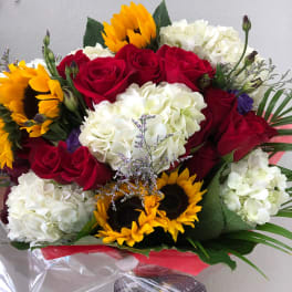 Bouquet of red roses, white hydrangeas, and sunflowers wrapped in clear plastic