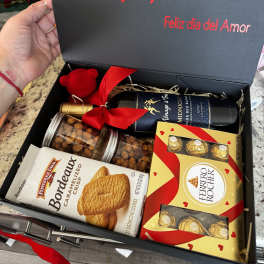 Gift box with wine, chocolates, cookies, and a small plush bear