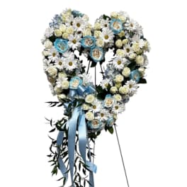 Heart-shaped floral wreath with white daisies, cream roses, and blue ribbon
