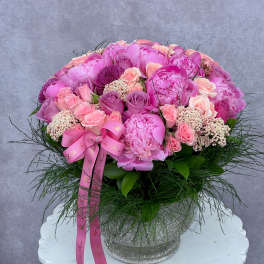 Pink floral arrangement in a glittery vase with a ribbon bow