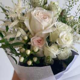 Bouquet of white and blush roses with airy filler and berries